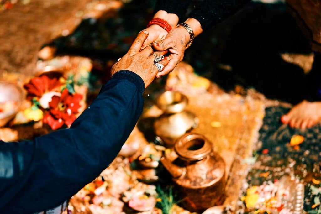 Zwei Hände die sich über zeremoniellen Gegenstände halten, Nepal reisen