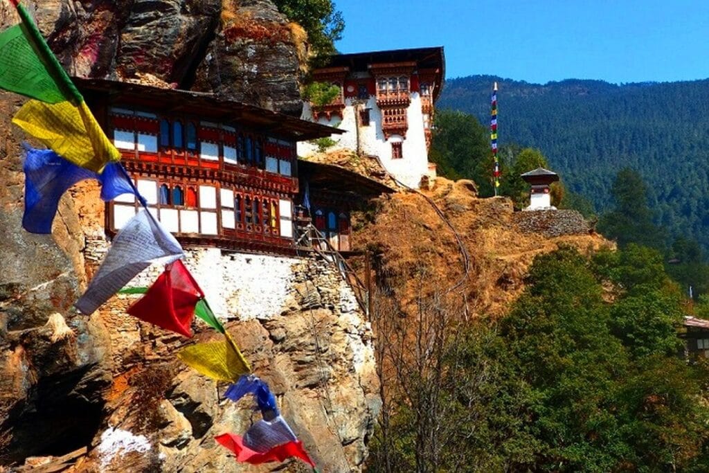 Klosteranlege in Bhutan mit Gebtsfahnen an der Seite hängend
