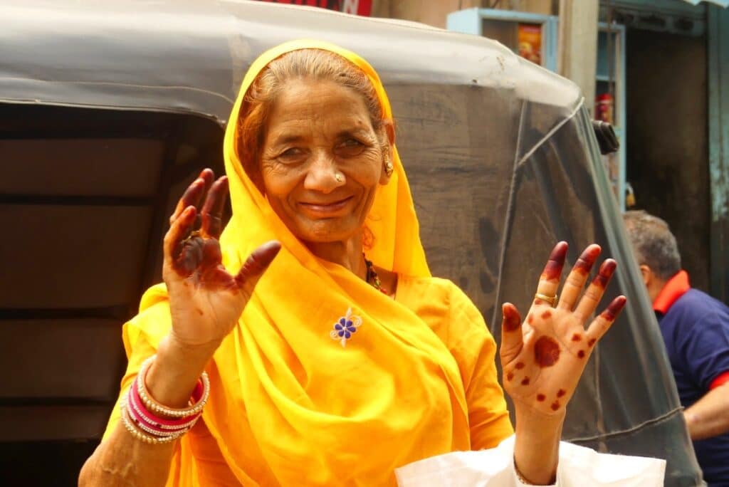 Indische Dame in gelbem Sari und mit Händen gefärbt mit Hena