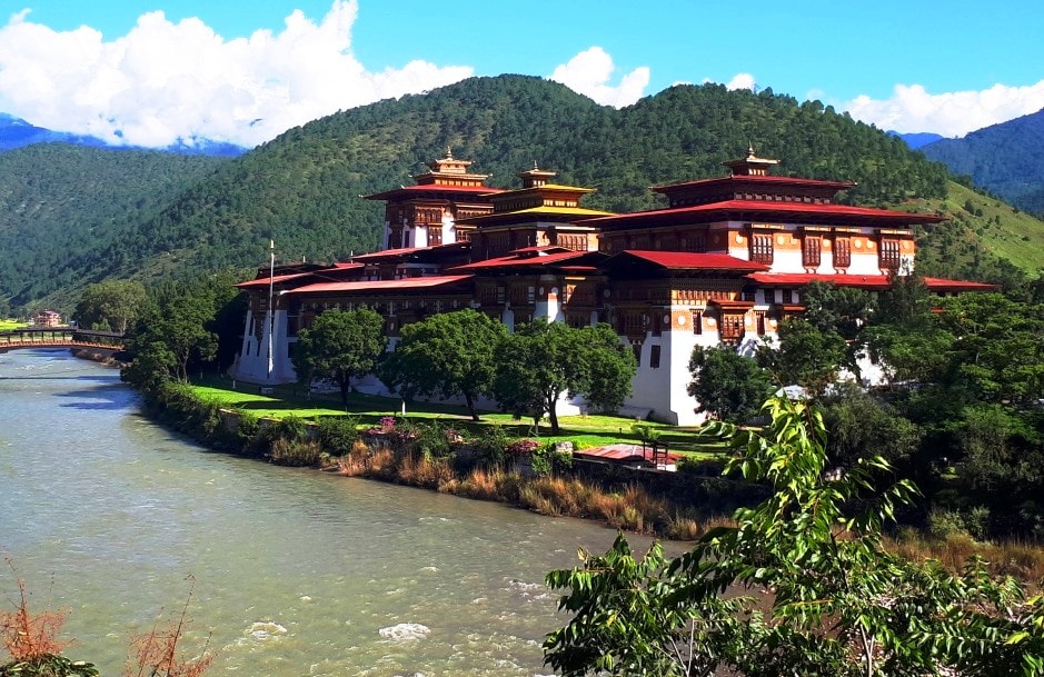 Punakha Dzong mit Fluss im Vordergrund und Hügeln im Hintergrund in Bhutan