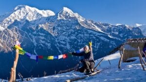 Frau hängt Gebetsfahnen mit Blick auf die Berge in Nepal
