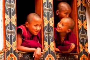 Kindermönche in Bhutan schauen aus dem Fenster