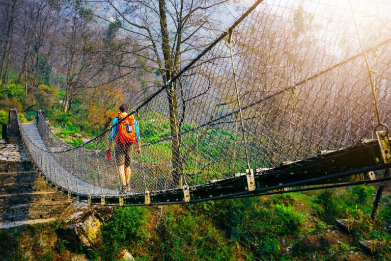 Trekker läuft über Hengebrücke in Nepal
