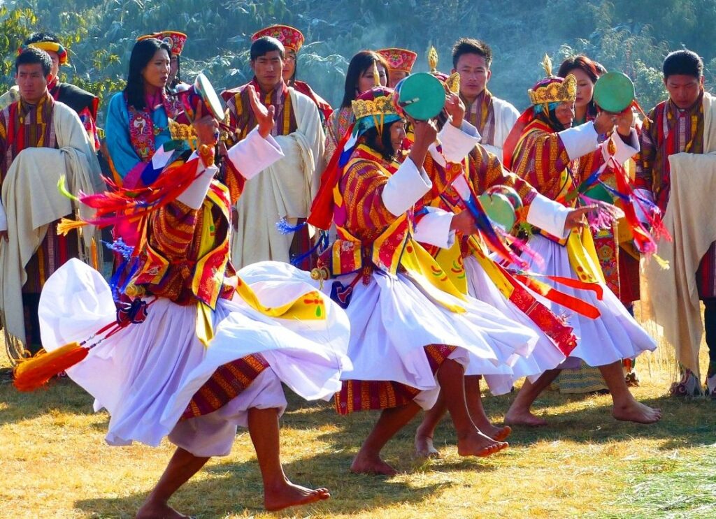 Techshus, gruppe verkleidete Männern tantzen lokale Täntze in Bhutan