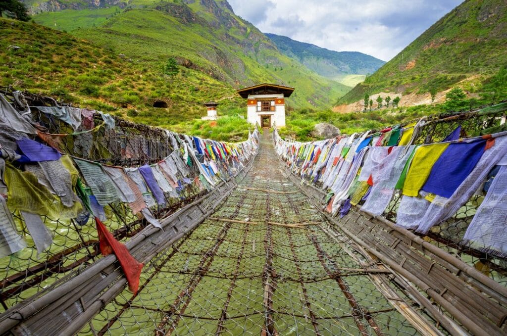 Hängebrücke in Bhutan mit bunten Gebetsfahnen
