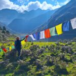 Druk Path Trekking in Bhutan - Trekkerin am Bergsee mit Gebestfahnen