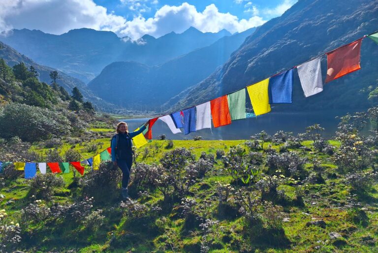 Druk Path Trekking in Bhutan - Trekkerin am Bergsee mit Gebestfahnen